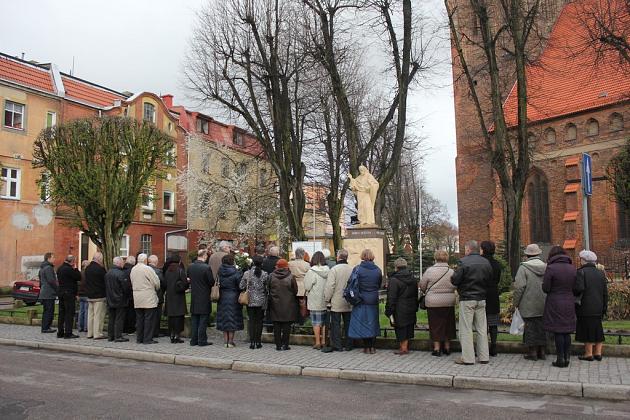 Kwiaty pod tablicą upamiętniającą ofiary katastrofy smoleńskiej